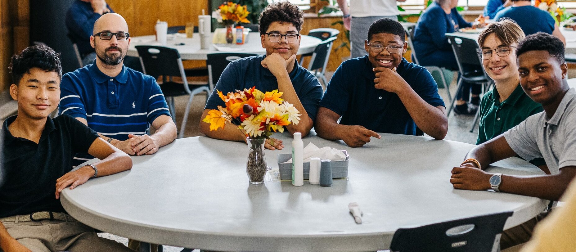 group of students and houseparent in the dining hall