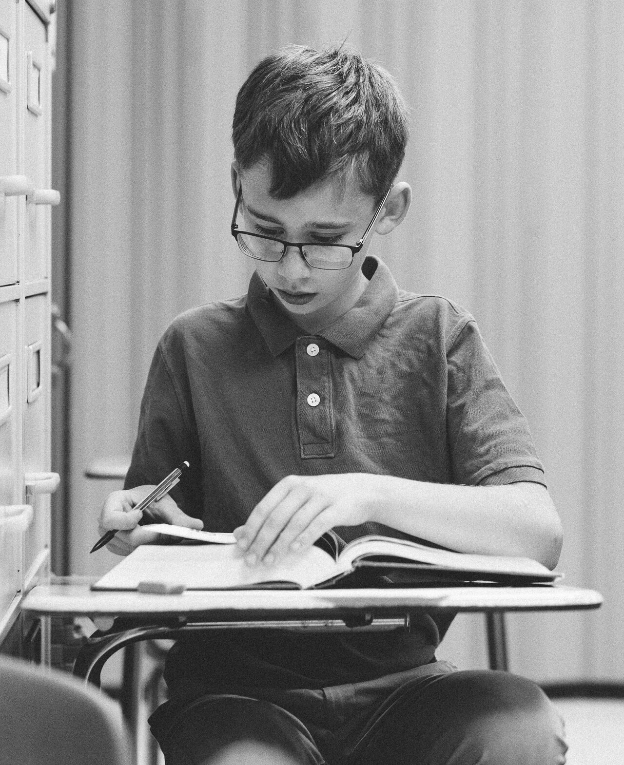 student in the classroom reading a book